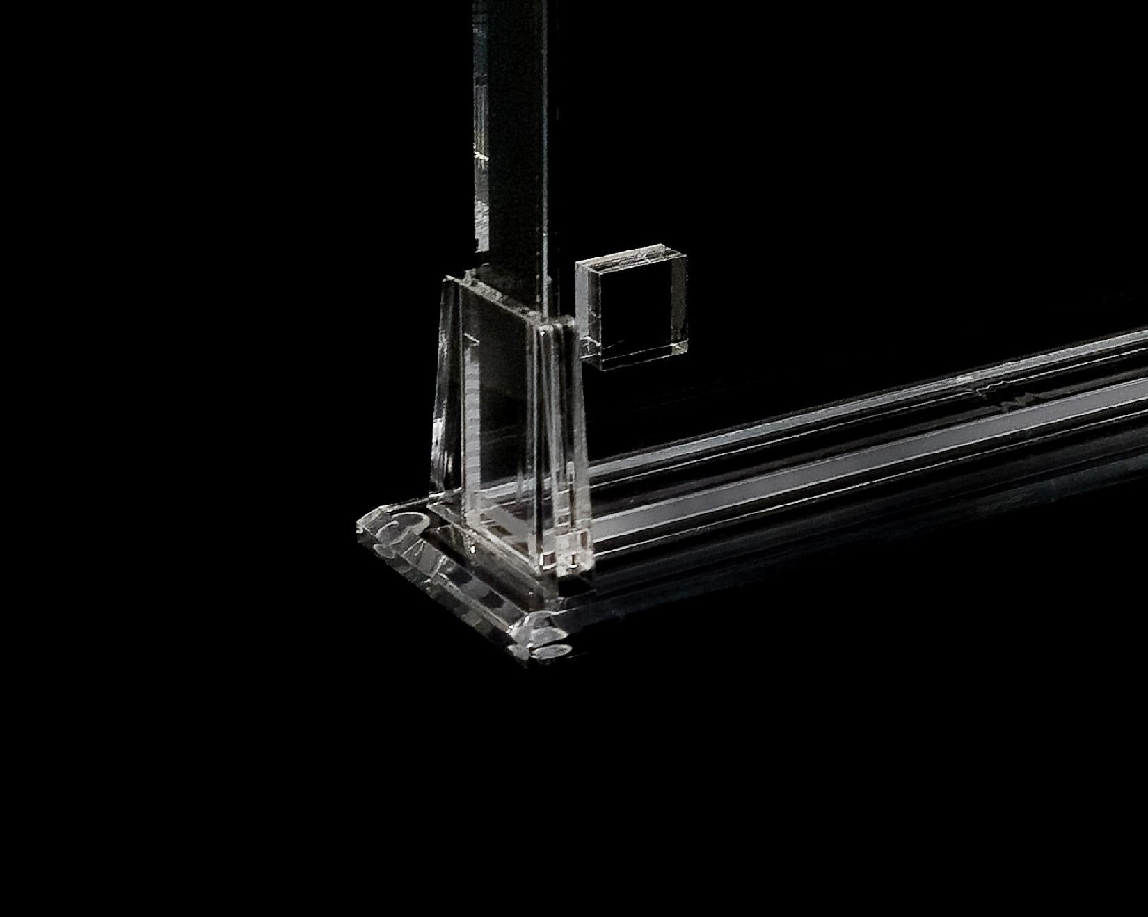 Clear acrylic stand with a rectangular base on a black background