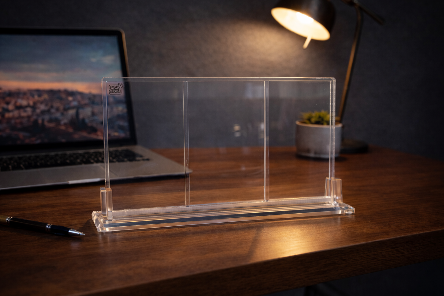 Clear acrylic stand on a desk with a laptop in the background