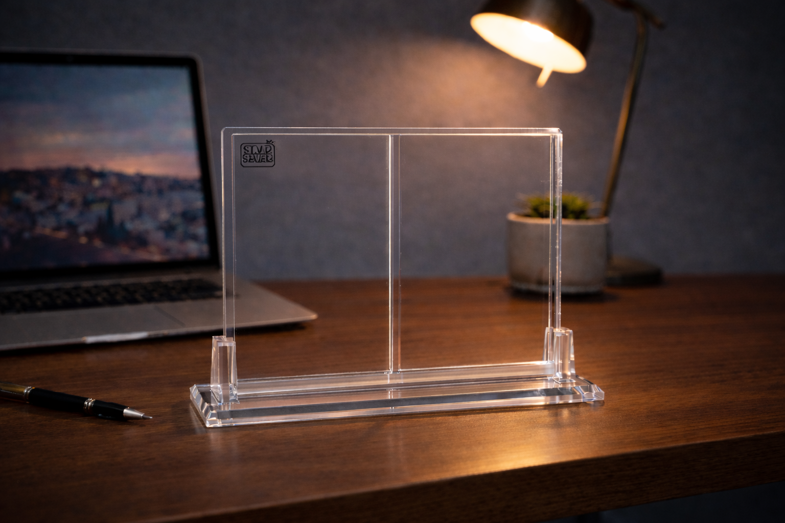 Clear acrylic stand on a desk with a laptop in the background
