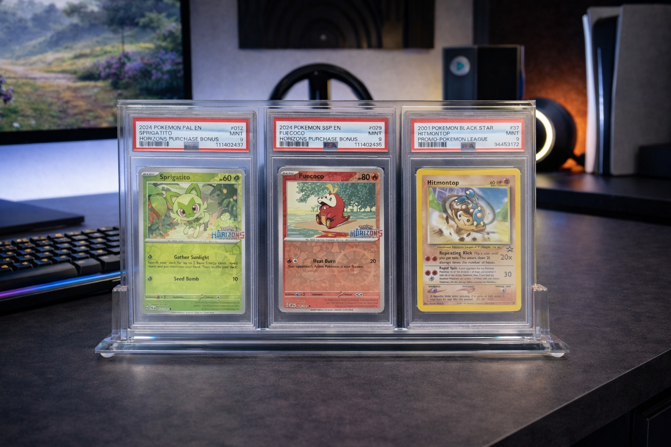 Three trading cards in protective cases on a desk with a blurred background