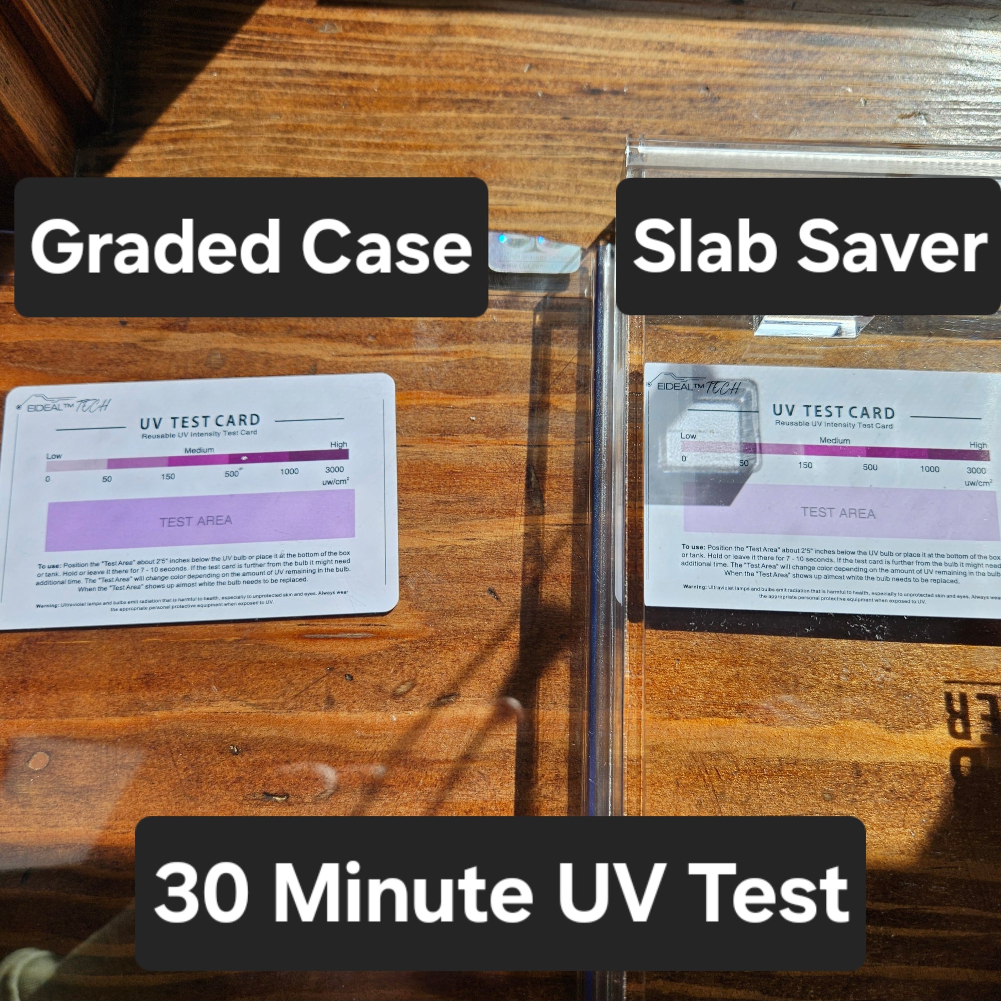Two wall-mounted UV protective cases labeled &#39;Graded Case&#39; and &#39;Slab Saver&#39; for comic books, with a 30 Minute UV Test card placed inside each case, displayed on a wooden surface.